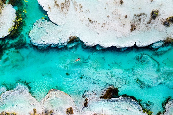 Woman swimming in blue water in Mexico