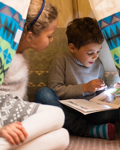 Children reading in a tent in a family friendly room